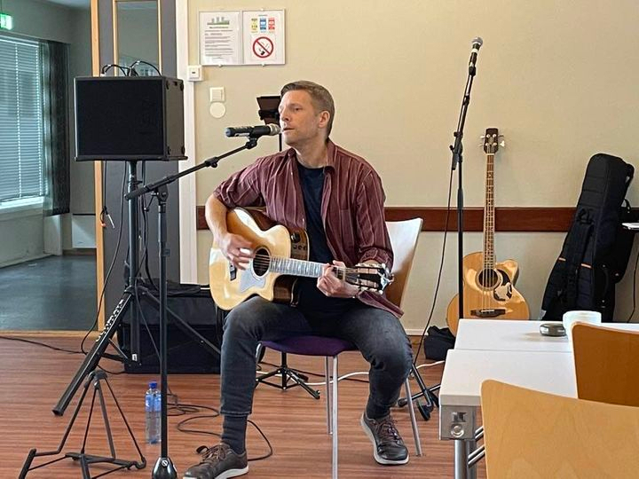 Cato sitter og synger og spiller gitar